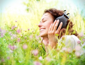 Beautiful Young Woman with Headphones Outdoors. Enjoying Music